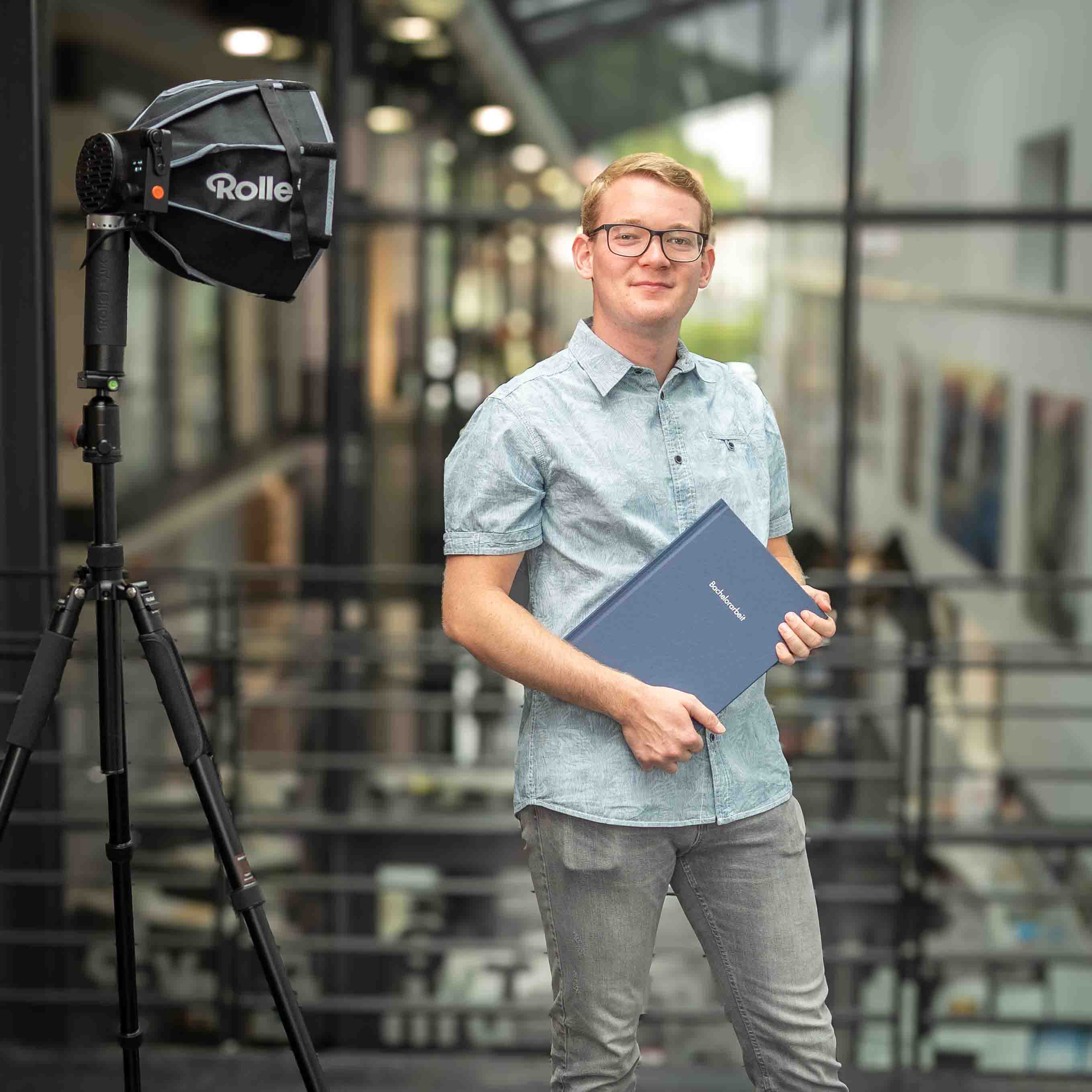 Nick Hartmann mit seiner Bachelorarbeit in der Hand